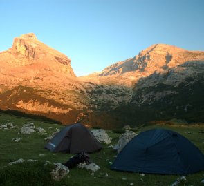 The first rays of the sun on Mount Piz Taibun and the ridge of Mount Lavarela