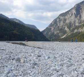 Kamenitá pláž jezera Leopoldsteiner See u bistra Seestüberl